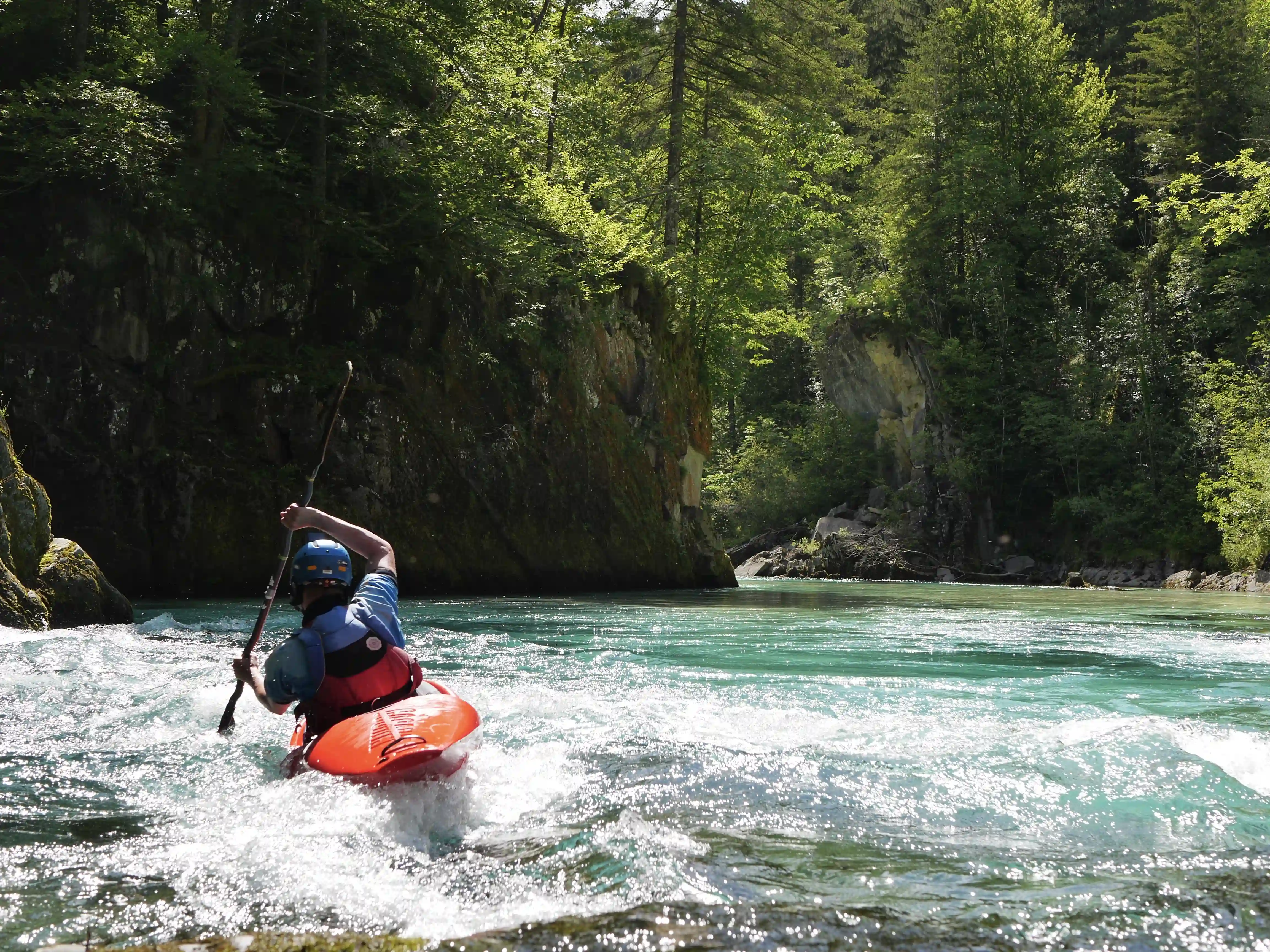 Red kayaker on blue river